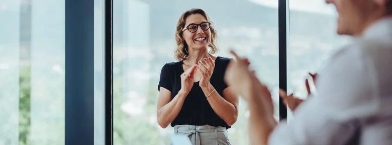 A businessperson claps with a colleague