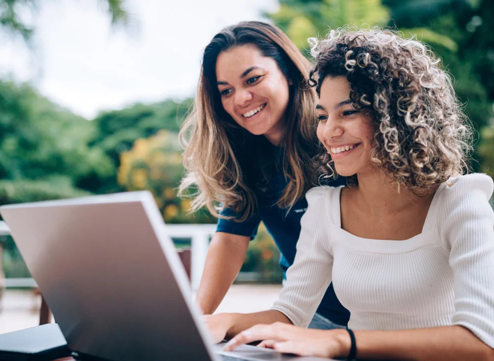 Two people looking at a laptop screen